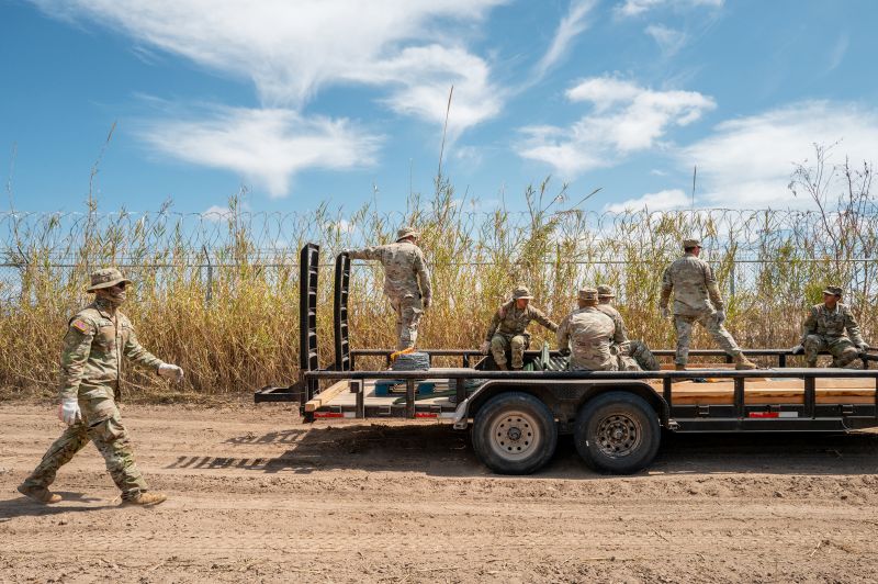 Texas National Guard soldiers lay material out in preparation to build and repair damaged fencing on the banks of the Rio Grande river near Shelby Park on March 21, in Eagle Pass, Texas.