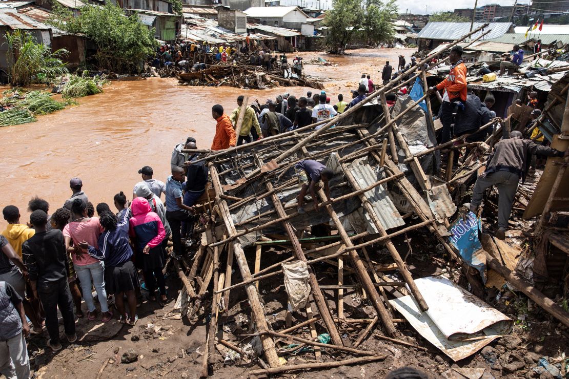 Residents of Mathare stand next to their destroyed houses by the Mathare river, following heavy rains in the capital, Nairobi, on April 24.