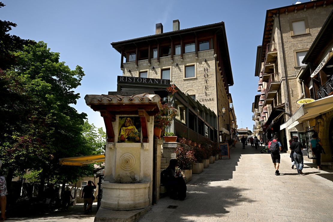 People walk in a pedestrian street in the center of San Marino on April 30, 2024.