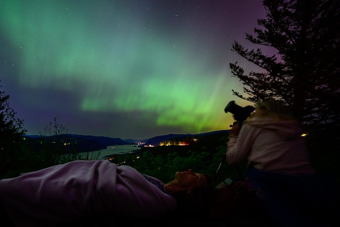 Kathryn Richer and her friend Andrea gaze upon the Northern Lights at Chanticleer Point Lookout on the Columbia River Gorge in the early morning hours of May 11 in Latourell, Oregon. 