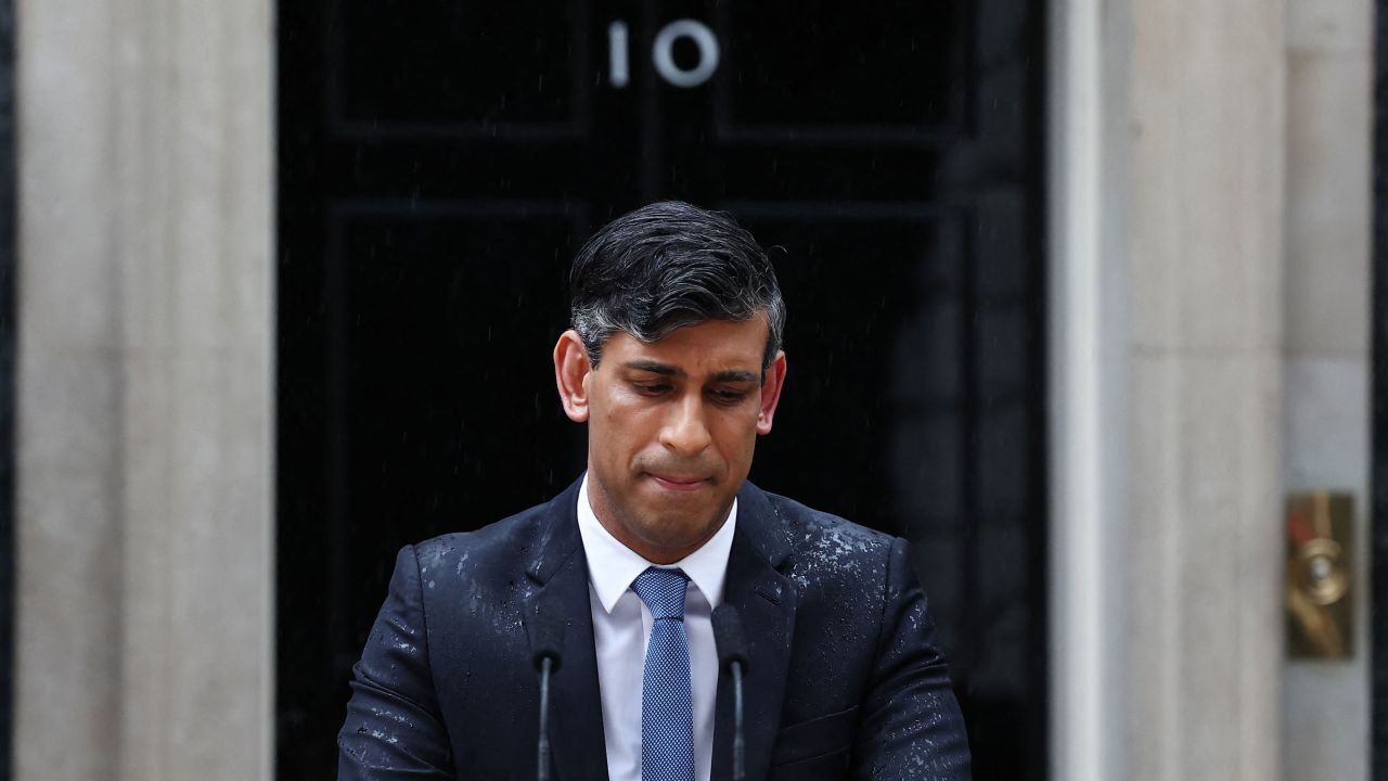 Britain's Prime Minister Rishi Sunak, soaked in rain, pauses as he delivers a speech to announce July 4 as the date of the UK's next general election, at 10 Downing Street in central London, on May 22. 