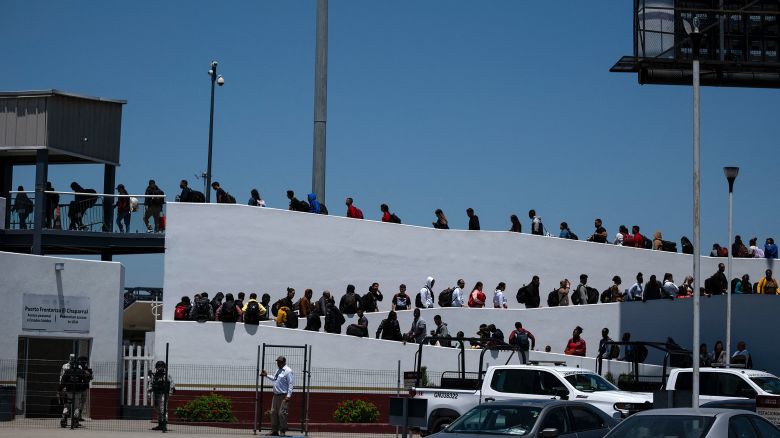 Asylum seekers walk for their asylum interview appointment with US authorities at the El Chaparral crossing port in Tijuana, Baja California State, Mexico, on May 18.