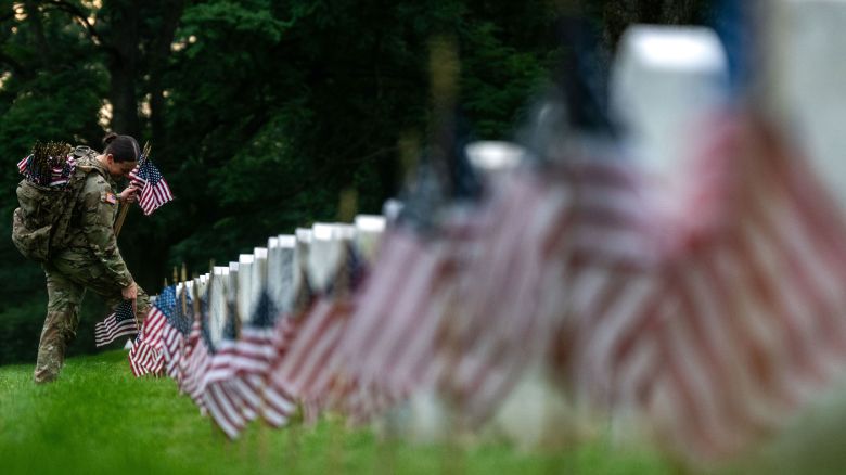 Members of the 3rd US Infantry Regiment place flags at the headstones of US military personnel buried at Arlington National Cemetery ahead of Memorial Day, on May 23, 2024 in Arlington, Virginia.