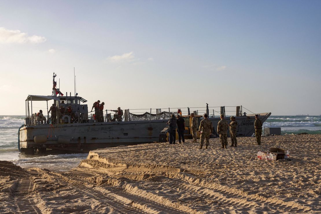 US soldiers stand next to one of two US Army vessels that ran aground in Israel's coastal city of Ashdod on May 25, 2024. The US military said four of its vessels, supporting a temporary pier built to deliver aid to Gaza by sea, had run aground in heavy seas.