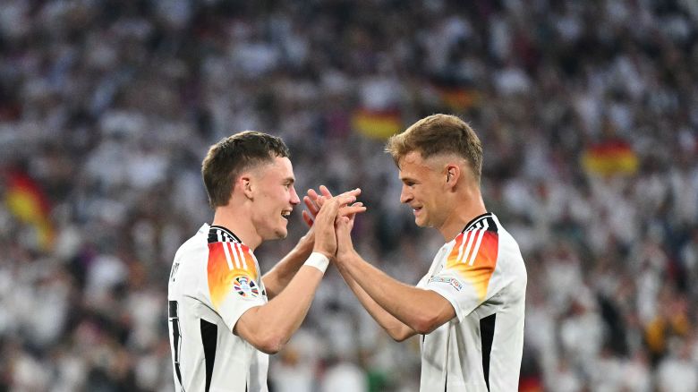 TOPSHOT - Germany's midfielder #17 Florian Wirtz (L) celebrates with Germany's defender #06 Joshua Kimmich after scoring his team's first goal during the UEFA Euro 2024 Group A football match between Germany and Scotland at the Munich Football Arena in Munich on June 14, 2024. (Photo by MIGUEL MEDINA / AFP) (Photo by MIGUEL MEDINA/AFP via Getty Images)