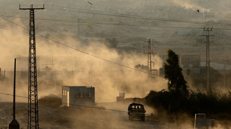 An Israeli army vehicle leaves the Gaza Strip as seen from a position on the Israeli side of the border on July 3.