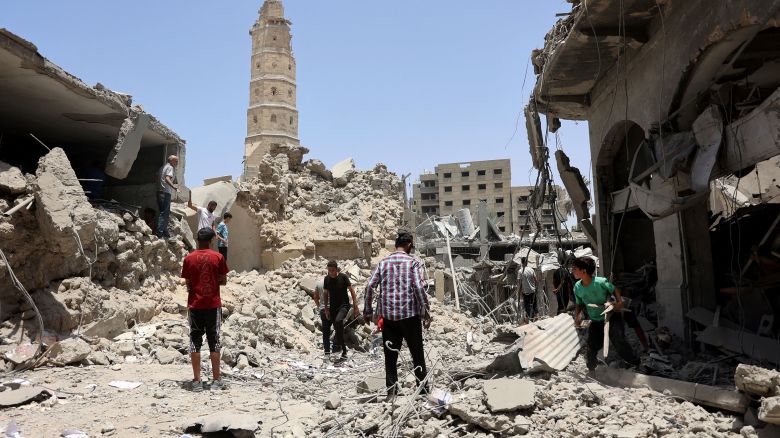 Rescuers stands on the rubble of destroyed buildings following Israeli bombardment near to the Great Omari Mosque in the Old City of Gaza City, which leads to the historical Qaysariyya market and gold shops, in Gaza City on July 4, 2024, amid the ongoing conflict between Israel and the Palestinian Hamas militant group.