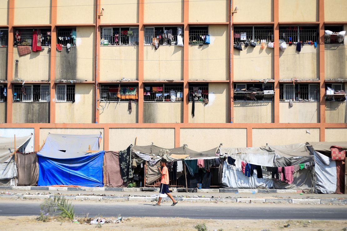 A Palestinian boy walks in front of a school used as a shelter by displaced people in Deir el-Balah in the central Gaza Strip on July 7.