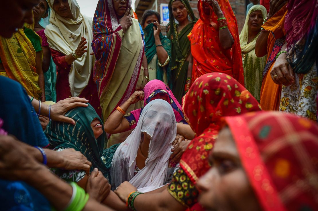 Relatives mourn outside of the home of three victims of the same family who died in the crush.