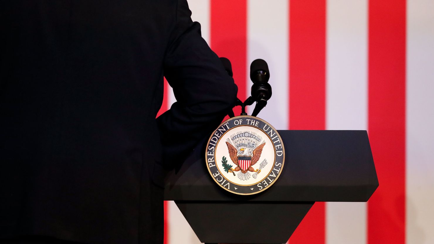 An aide attaches an official seal to the podium before US Vice President Kamala Harris attends a moderated conversation with former Trump administration national security official Olivia Troye and former Republican voter Amanda Stratton on July 17, 2024, in Kalamazoo, Michigan.