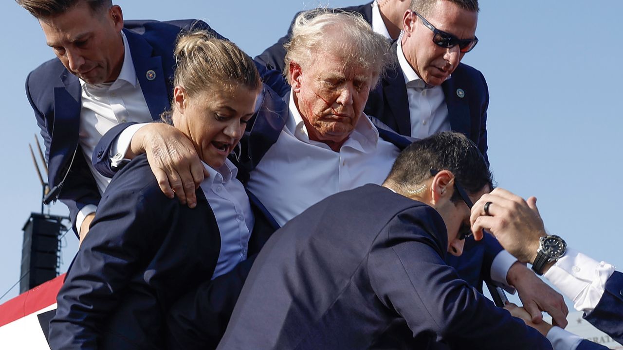 BUTLER, PENNSYLVANIA - JULY 13: Republican presidential candidate former President Donald Trump is rushed offstage by U.S. Secret Service agents after being grazed by a bullet during a rally on July 13, 2024 in Butler, Pennsylvania. Butler County district attorney Richard Goldinger said the shooter is dead after injuring former U.S. President Donald Trump, killing one audience member and injuring another in the shooting. (Photo by Anna Moneymaker/Getty Images)