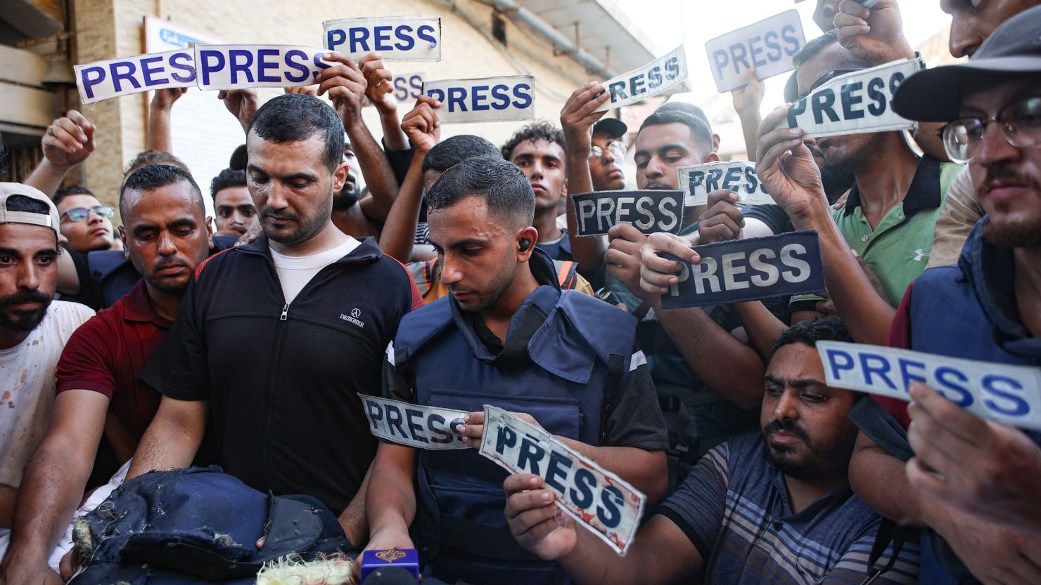 Mourners and colleagues hold 'press' signs surround the body of Al-Jazeera Arabic journalist Ismail al-Ghoul, killed along with his cameraman Rami al-Refee in an Israeli strike during their coverage of Gaza's Al-Shati refugee camp, on July 31.
