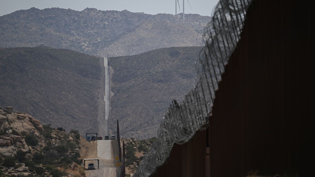 TOPSHOT - US Customs and Border Protection Border Patrol vehicles sit parked along border wall fencing between the United States and Mexico on August 1 in Jacumba Hot Springs, California. 