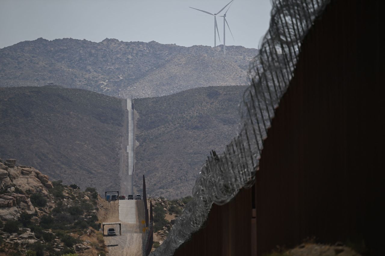 TOPSHOT - U.S. Customs and Border Protection Border Patrol vehicles are parked along the border wall between the United States and Mexico on August 1 in Jacumba Hot Springs, California. 