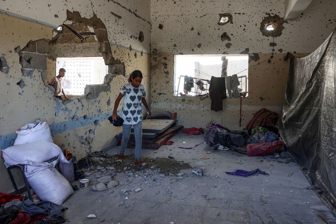 A young Palestinian woman checks the damage inside a classroom at the al-Zahra school used as a refuge by displaced Palestinians, after it was hit by an Israeli strike in the Shujaiya neighborhood of Gaza City on August 8.