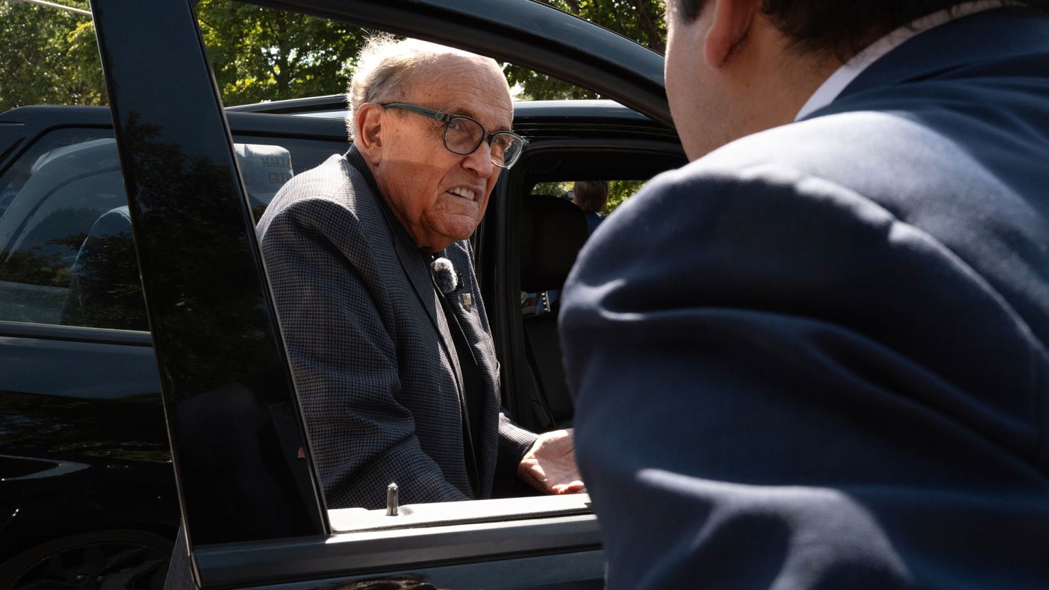 Former New York City Mayor Rudy Giuliani climbs into his vehicle after speaking with people and police outside a designated protest area near the United Center which is hosting the Democratic National Convention on August 20 in Chicago.