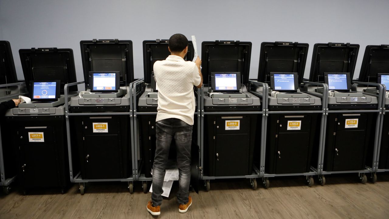 A Supervisor and Elections office staff member runs sample voting ballots through voting machines during a test run at the Supervisor of Elections Office in Tampa, Florida, on October 3, 2024. 