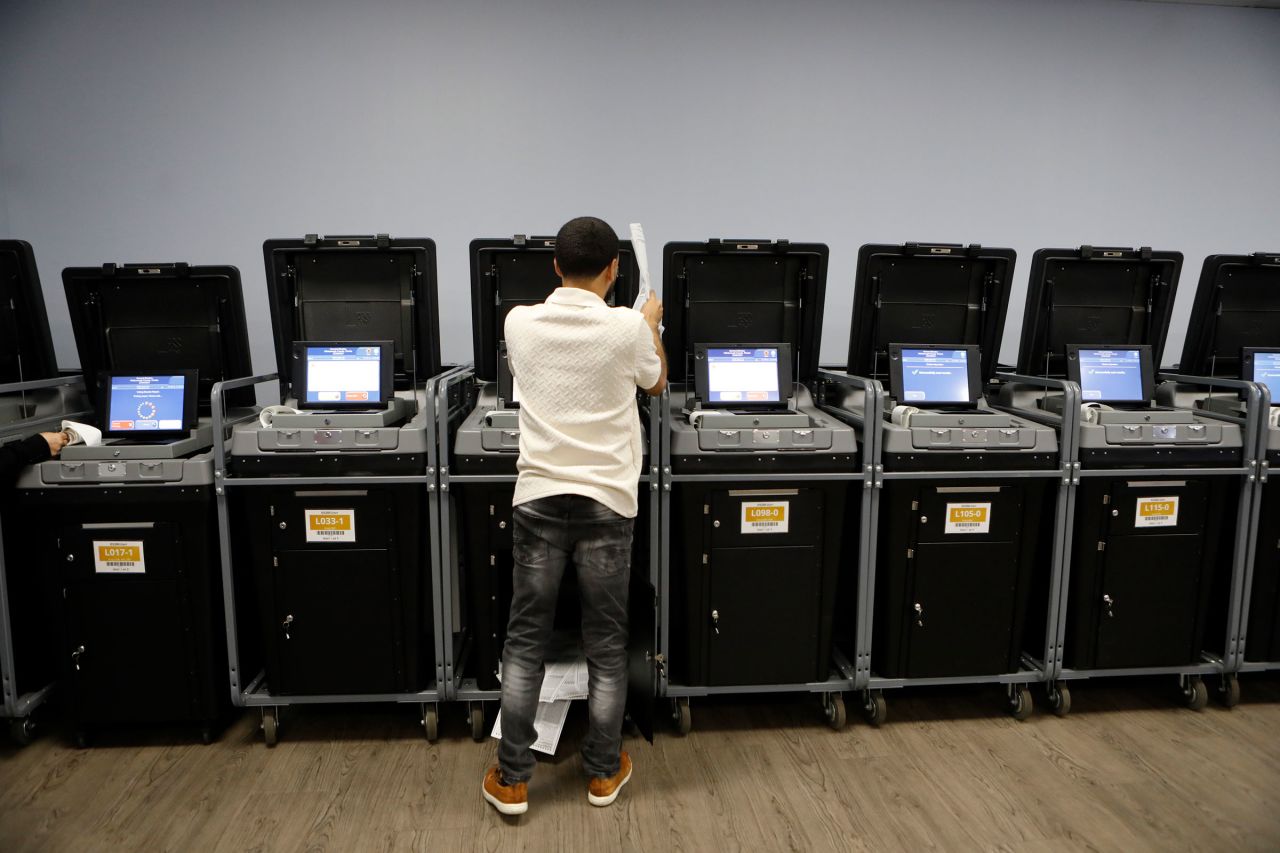 A Supervisor and Elections office staff member runs sample voting ballots through voting machines during a test run at the Supervisor of Elections Office in Tampa, Florida, on October 3, 2024. 