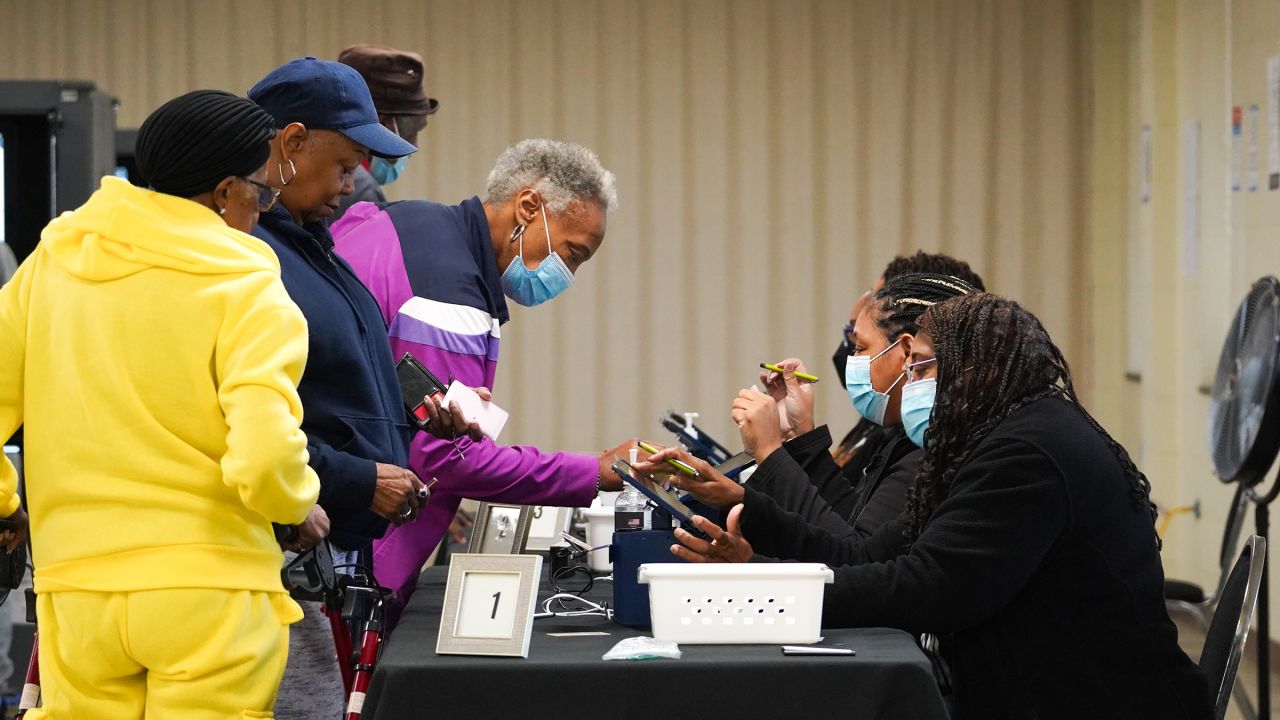 People sign in to cast their votes on the first day of early voting at East Point First Mallalieu United Methodist Church on October 15 in Atlanta.