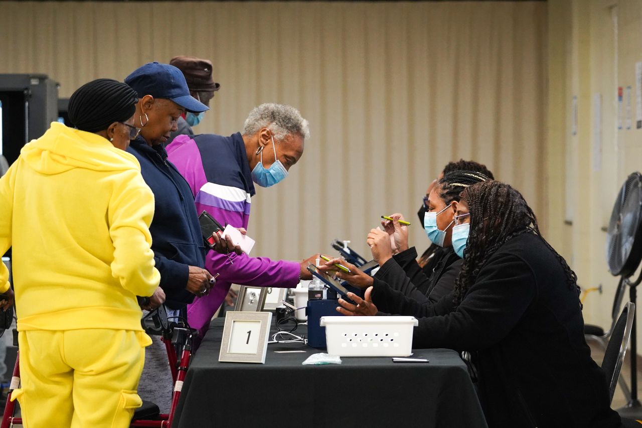 People sign in to cast their votes on the first day of early voting at East Point First Mallalieu United Methodist Church on October 15 in Atlanta.