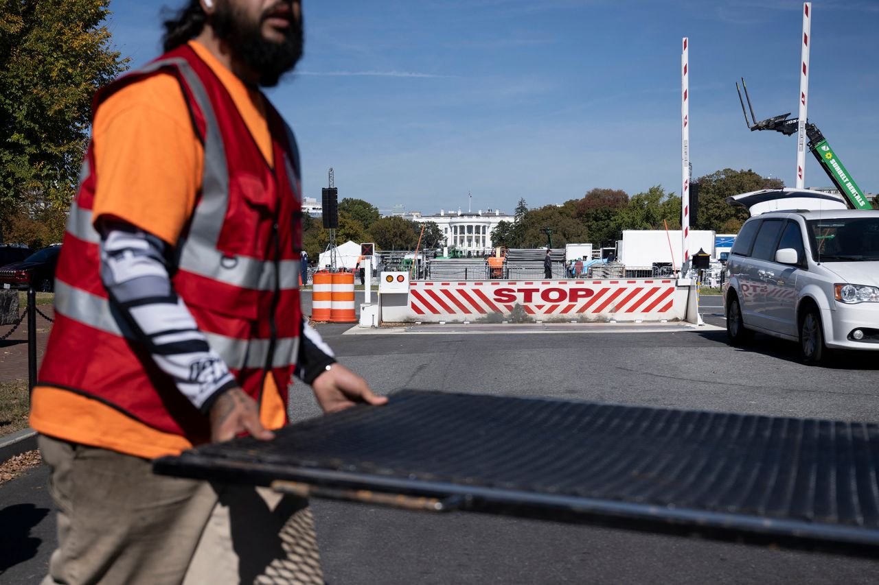 Workers install security fencing around the White House grounds in preparation for a rally with US Vice President Kamala Harris on the Ellipse in Washington, DC, on October 28.