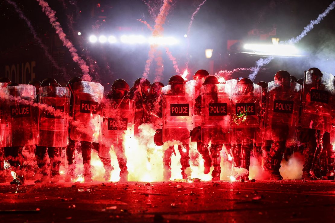 Fireworks fired by protestors explode along police lines as the two sides clash during a demonstration against the government's decision to delay European Union membership talks amid a post-election crisis, outside Georgia Parliament in Tbilisi, early on December 1.