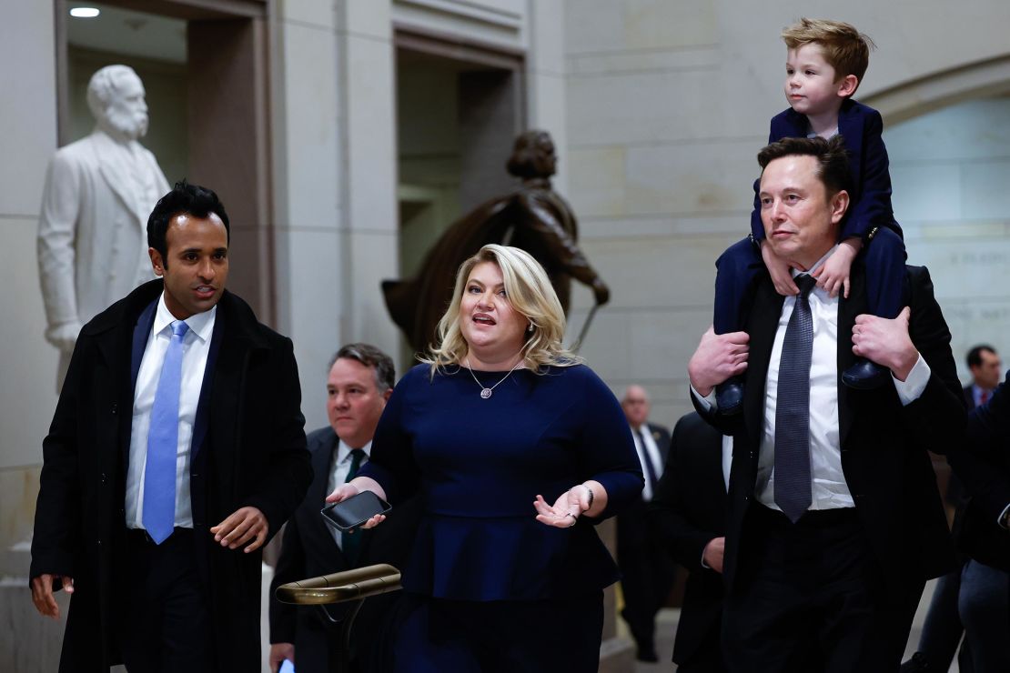 Elon Musk, right, carries his son on his shoulders at the US Capitol following a meeting with businessman Vivek Ramaswamy, left, Rep. Kat Cammack, center, and other members of the US Congress on December 5, in Washington, DC.