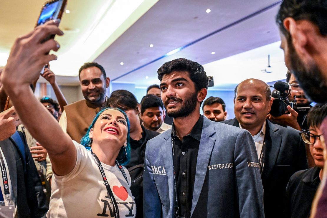 A fan takes a selfie with India's grandmaster Gukesh Dommaraju, center, after his victory against China's chess grandmaster Ding Liren in game 14 of the 2024 FIDE World Chess Championship in Singapore on December 12.