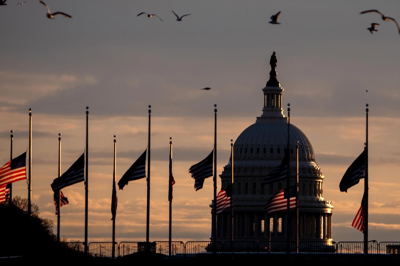 The dome of the US Capitol Building is visible as flags are lowered to half-staff at the Washington Monument following the death of former President Jimmy Carter on December 30 in Washington, DC. 