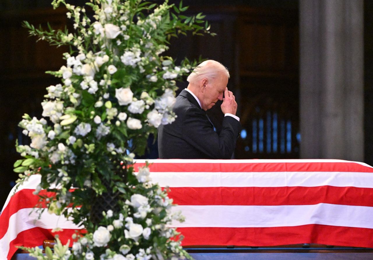 President Joe Biden makes the sign of the cross as he walks past the casket of former President Jimmy Carter during his State Funeral Service at the Washington National Cathedral in Washington, DC, on January 9.