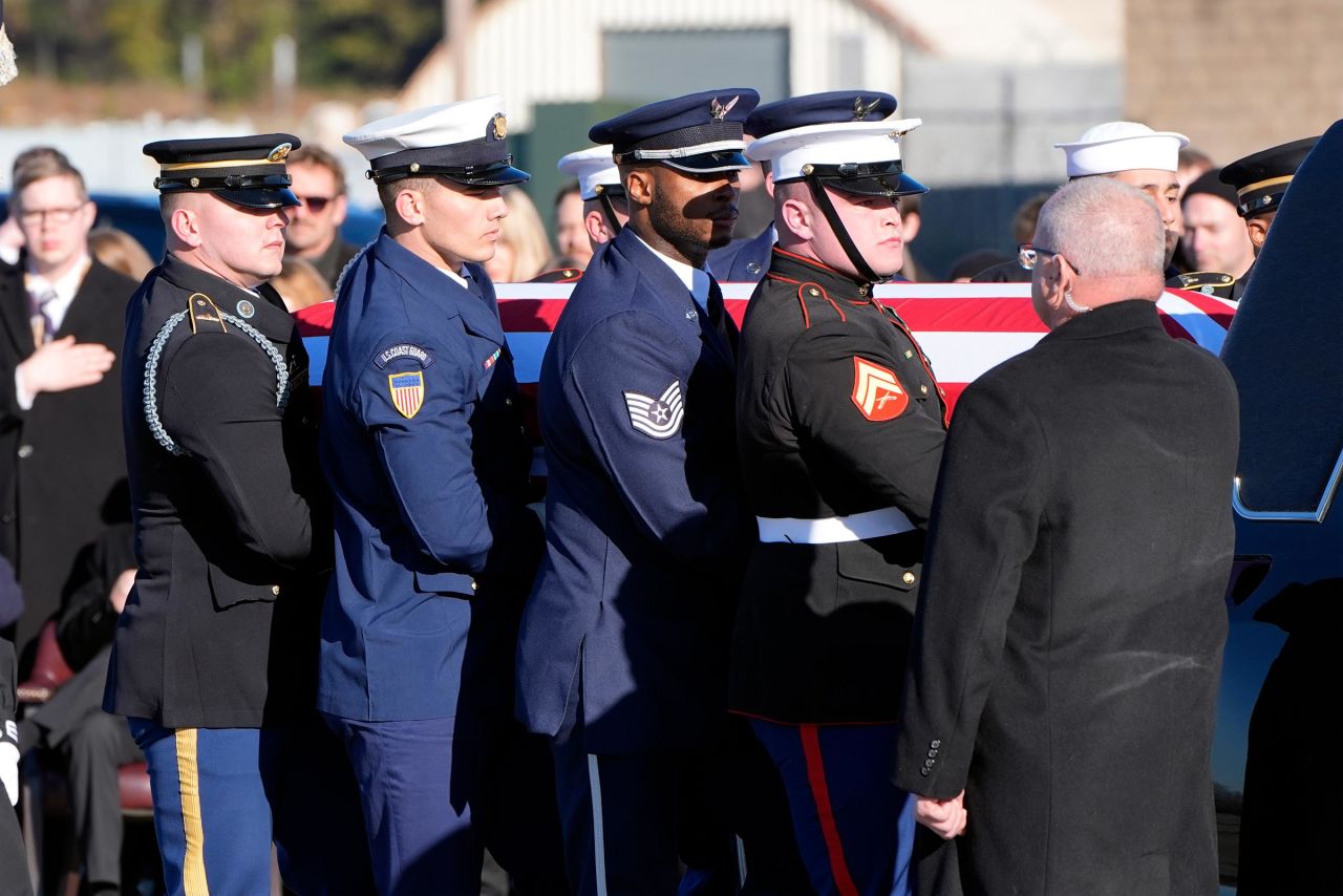 The flag-draped casket of former President Jimmy Carter is placed into the hearse by a joint services body bearer team from Special Air Mission 39 at Lawson Army Airfield, on January 9, 2025 in Fort Moore, Georgia.