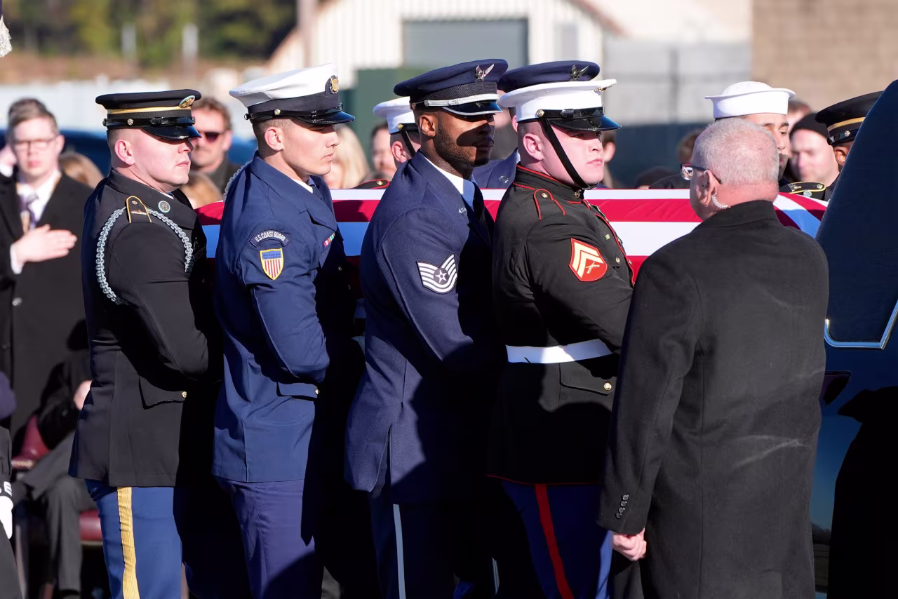 The flag-draped casket of former President Jimmy Carter is placed into the hearse by a joint services body bearer team from Special Air Mission 39 at Lawson Army Airfield, on January 9, 2025 in Fort Moore, Georgia.