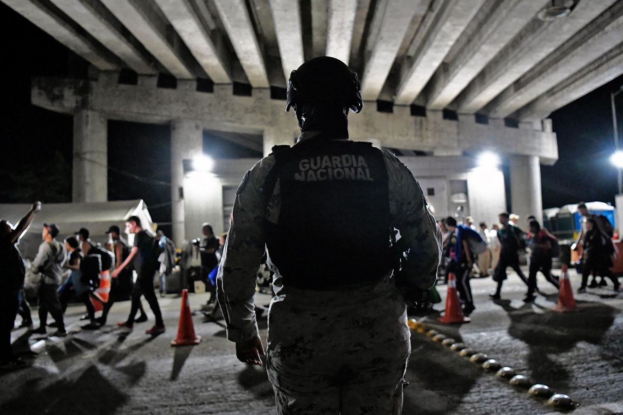 A Mexican National Guard member stands guard as migrants from a caravan in Tapachula, Chiapas state, Mexico, head to the US border on January 20, 2025. 