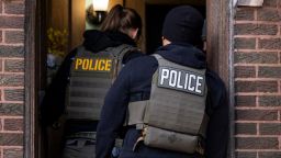 Agentes del Servicio de Inmigración y Control de Aduanas de Estados Unidos ingresan a un edificio de apartamentos durante una operación policial dirigida por varias agencias en Chicago el 26 de enero.