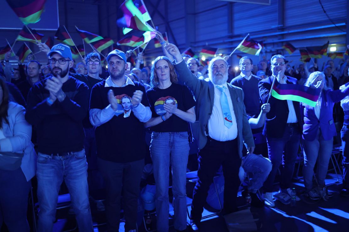 Supporters of the far-right Alternative for Germany (AfD) political party cheer and wave German flags as they welcome AfD chancellor candidate Alice Weidel to speak at the AfD election campaign launch rally on January 25, 2025 in Halle, Germany.