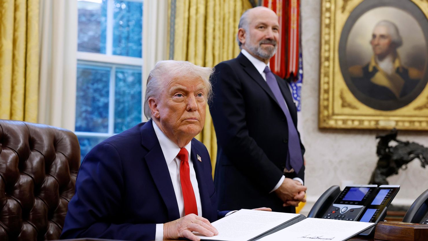 President Donald Trump, alongside Howard Lutnick, his nominee for Commerce Secretary, speaks to reporters in the Oval Office of the White House on February 3, in Washington, DC. 