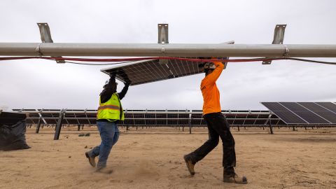 Workers install solar panels for the Los Angeles Department of Water and Power's biggest solar and battery storage plant, the Eland Solar and Storage Center in the Mojave Desert of Kern County, on November 25, 2024, near California City, California.
