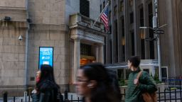 People walk along Wall Street by the New York Stock Exchange (NYSE) on March 11 in New York City.