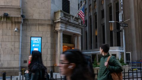 People walk along Wall Street by the New York Stock Exchange (NYSE) on March 11 in New York City.