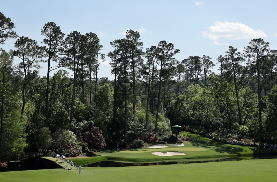 Dustin Johnson, Nick Taylor and Justin Hastings cross the Hogan Bridge at the 12th hole during the first round of the 2025 Masters Tournament at Augusta National Golf Club on April 10 in Augusta, Georgia.