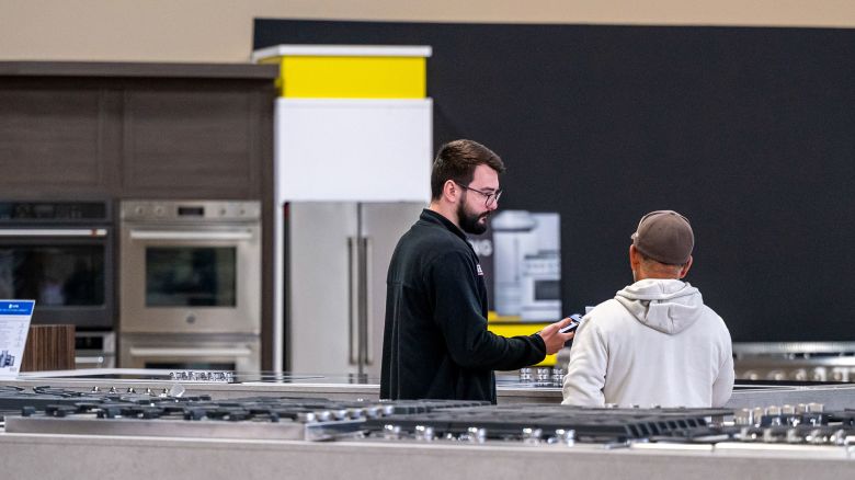 A salesperson assists a customer inside an appliance store in Sacramento, California, on Thursday, April 17.