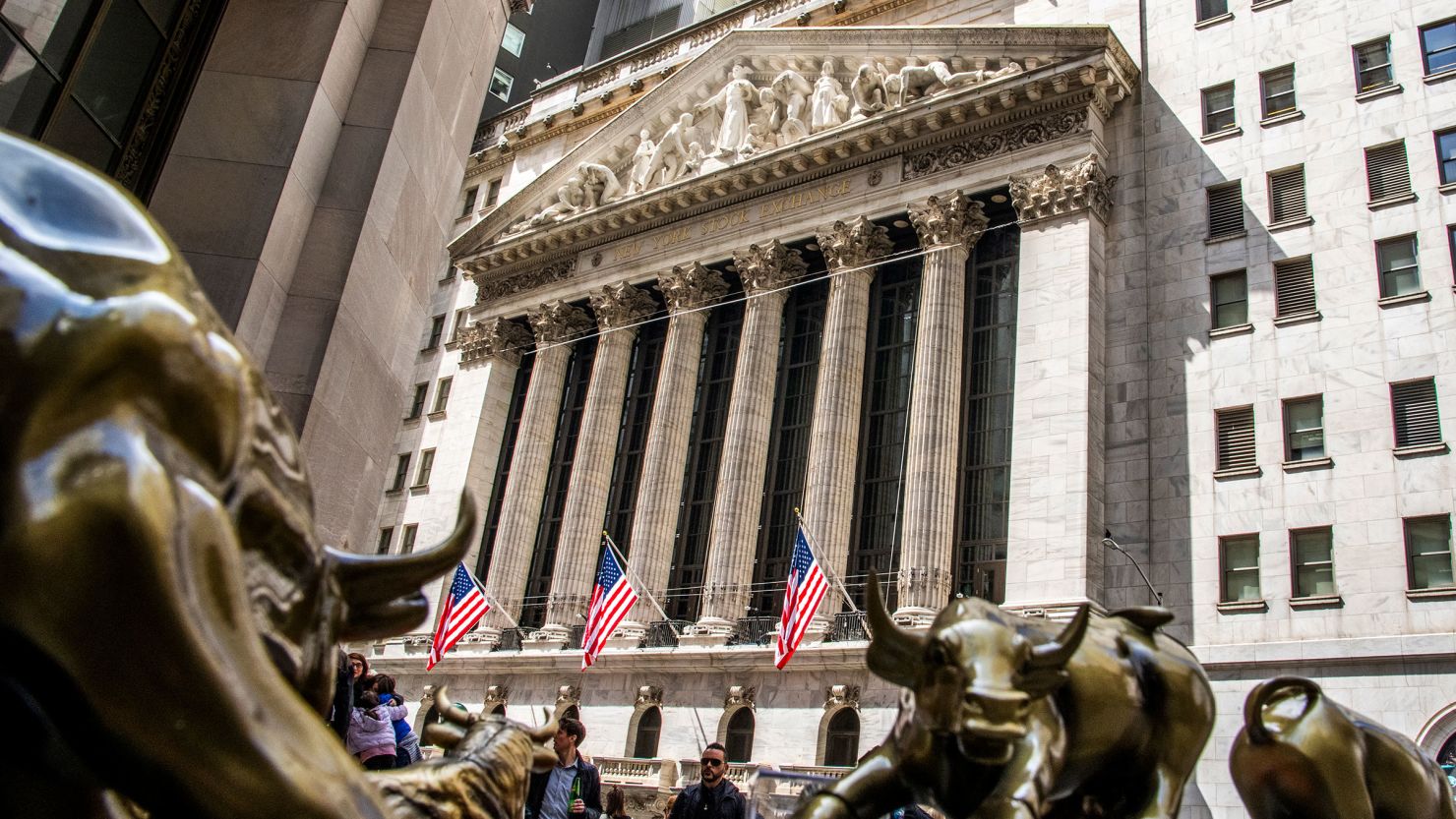 People walk in front of the New York Stock Exchange on April 14 in New York City.