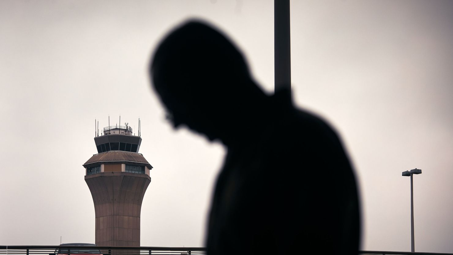 A man stands outside Terminal C with the airport control tower in the background at Newark Liberty International Airport, on May 6 in Newark, New Jersey.
