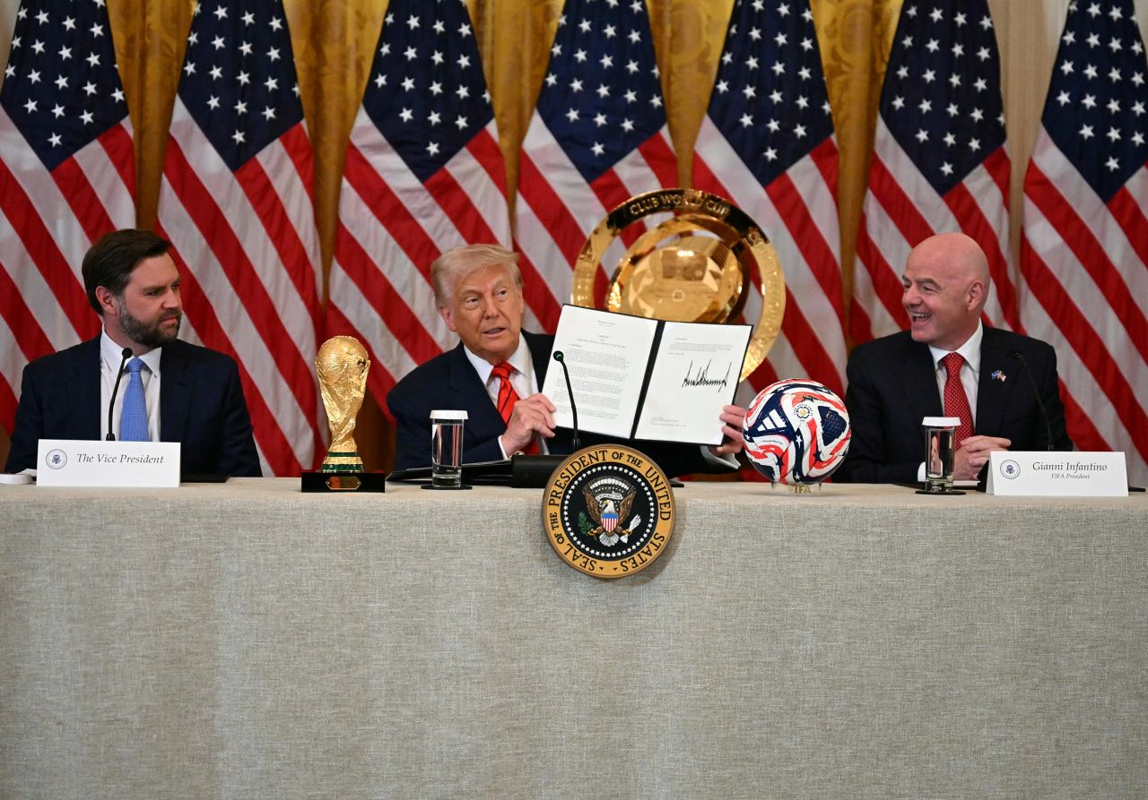 President Donald Trump holds up a document creating the 