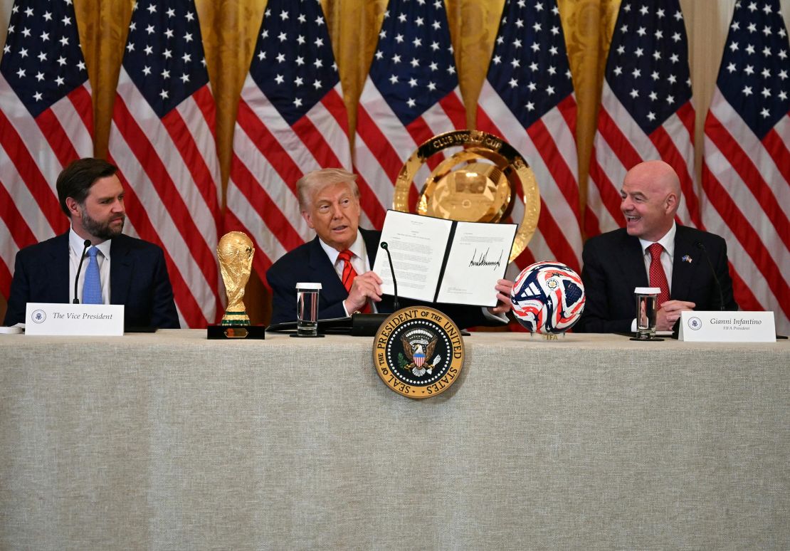 President Donald Trump holds up a document creating the 