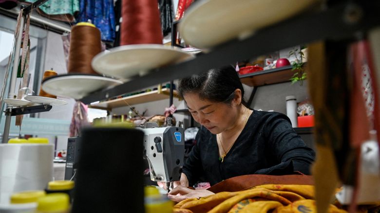 A woman sews clothing at the Keqiao China Textile City, one of the biggest textile markets in Asia, in Shaoxing in China's eastern Zhejiang province on May 8.