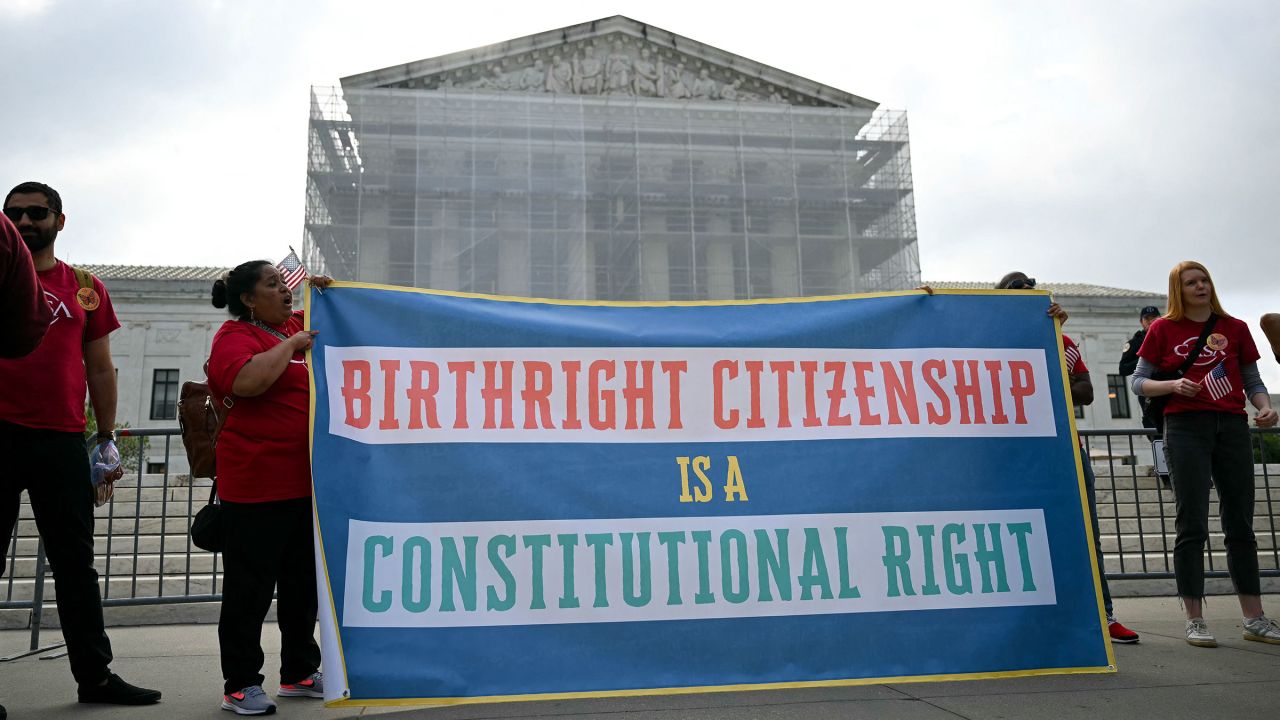 People hold a sign as they participate in a protest outside the US Supreme Court over President Donald Trump's move to end birthright citizenship as the court hears arguments over the order in Washington, DC, on May 15.