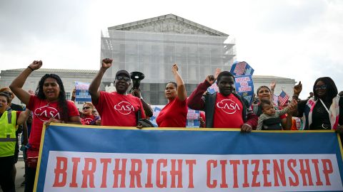 People hold a banner as they participate in a protest outside the US Supreme Court over President Donald Trump's move to end birthright citizenship as the court hears arguments over the order in Washington, DC, on May 15.