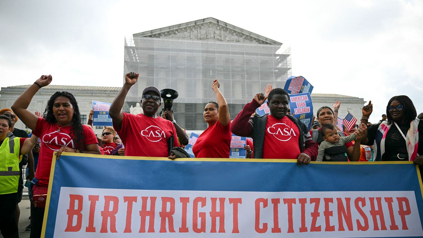 People hold a banner as they participate in a protest outside the US Supreme Court over President Donald Trump's move to end birthright citizenship as the court hears arguments over the order in Washington, DC, on May 15.