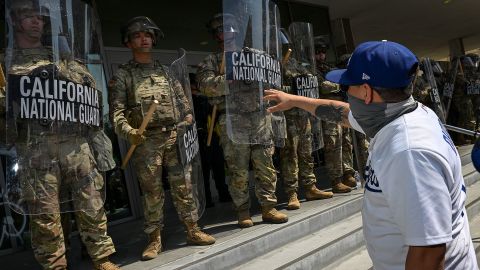 Members of the California National Guard watch as protesters are seen outside the Metropolitan Detention Center on June 9 in Los Angeles.